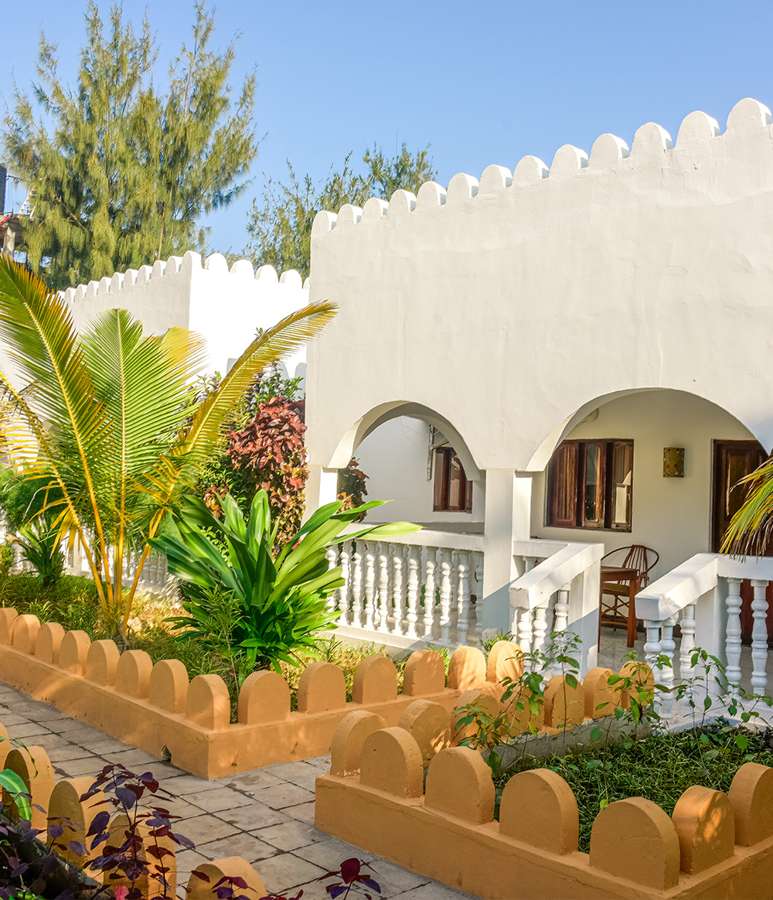 Deluxe room in a white arched bungalow with tropical garden at Amaan
